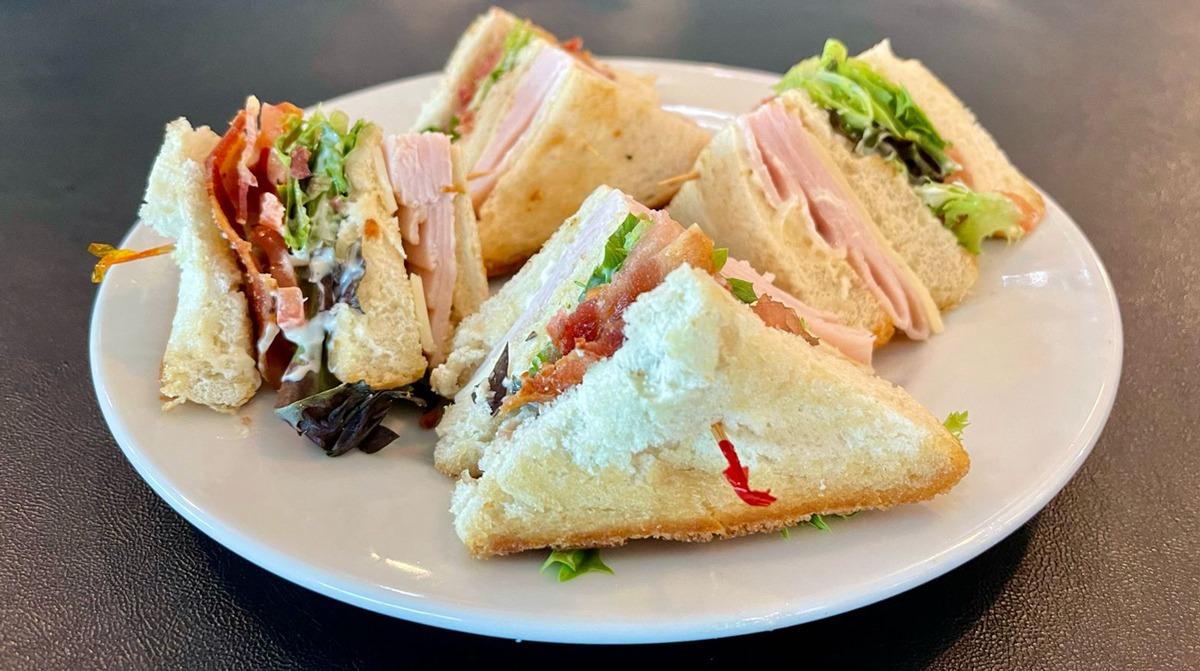 Club sandwich cut into triangles on a white plate