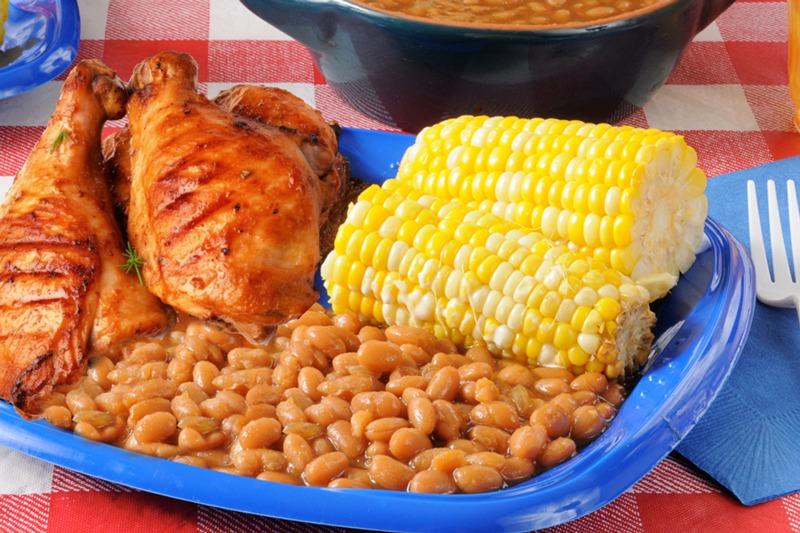 plate of bbq chicken with corn on the cob and baked beans
