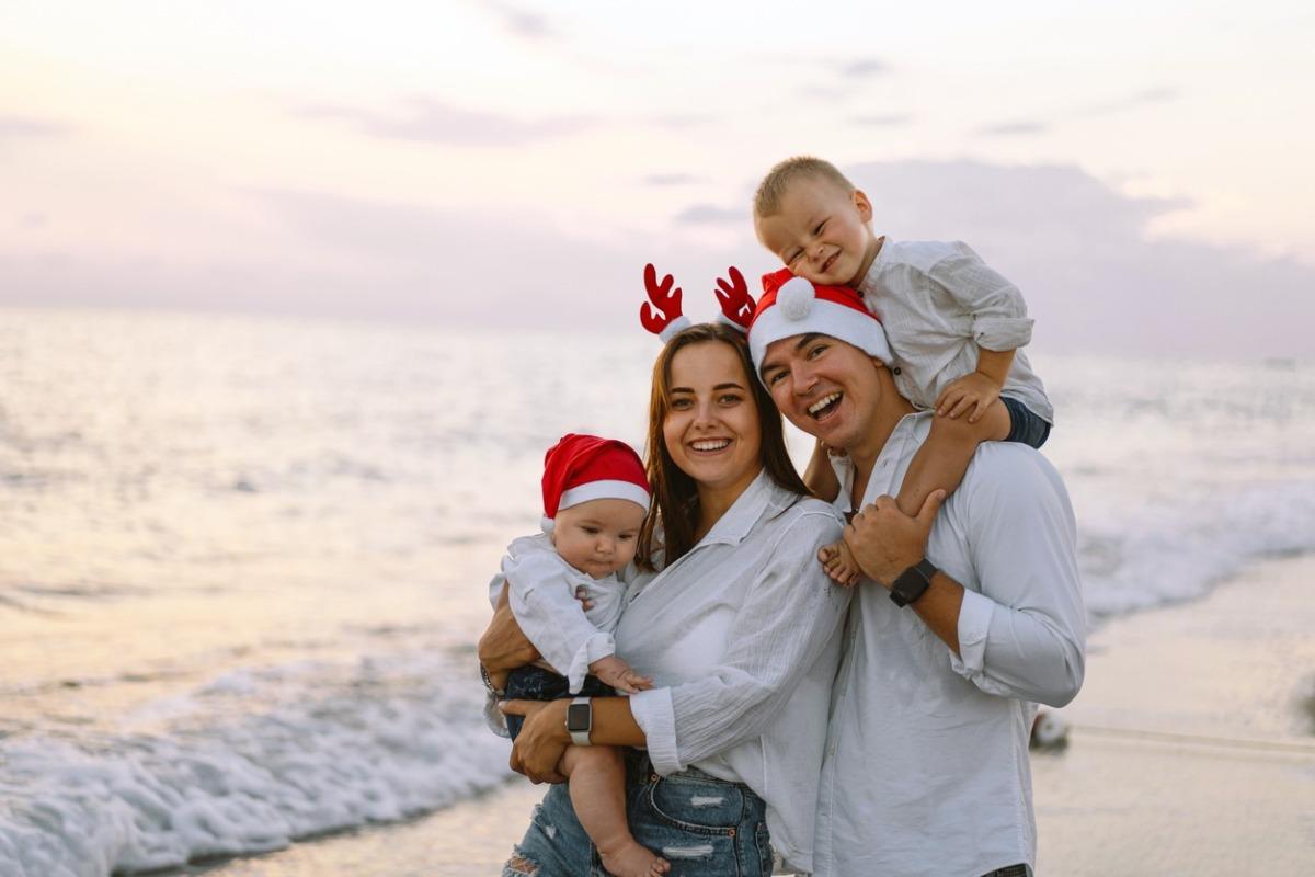 Family in a red Santa hat walk on the beach. Family celebrate Christmas and new year at North Myrtle Beach at Avista Resort.