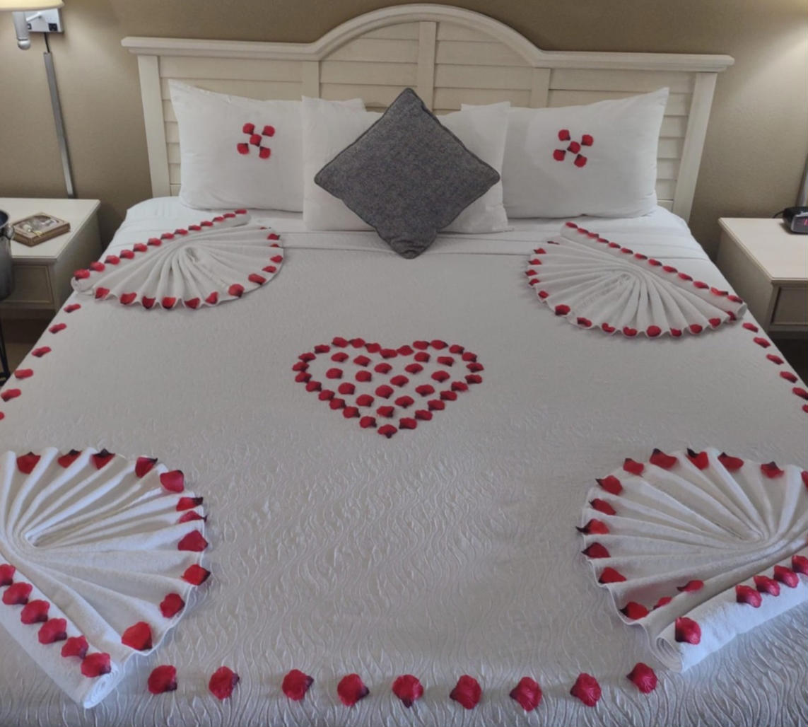 Group of smiling people wearing hawaiian leis at an outdoor table