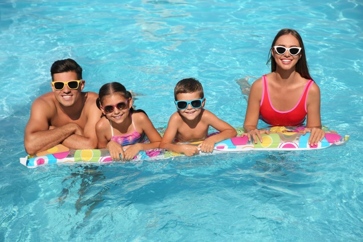 family relaxing in pool at resort