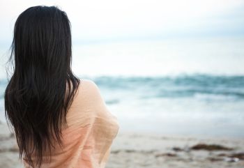 A young woman looking out over the ocean from the beach in Myrtle Beach