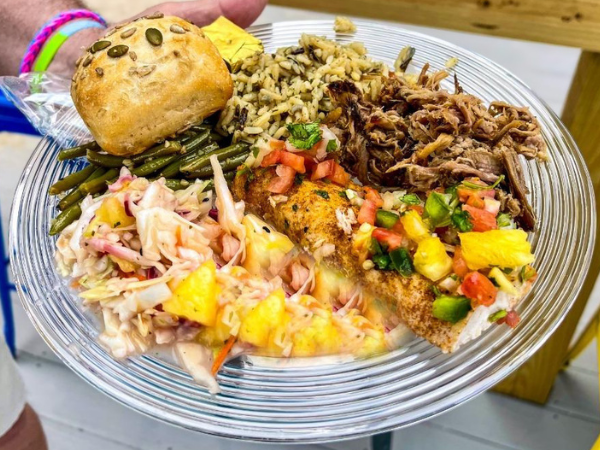 Image of plated food for Avista Resort's luau show with kalua pokr, rice and a dinner roll
