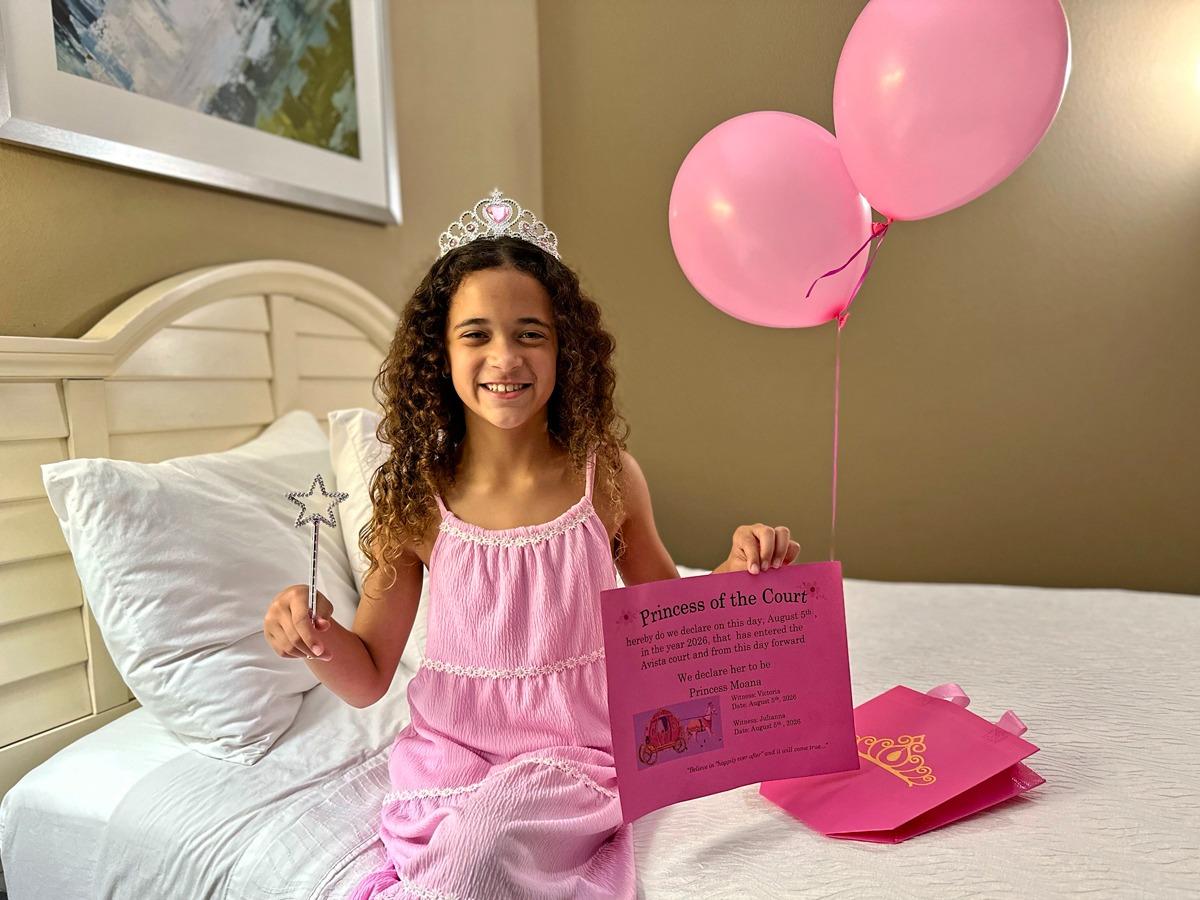 woman and small child wearing a tiara with a colorful balloon background