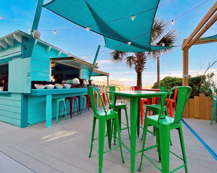 Outdoor beach bar with high top tables and string lights