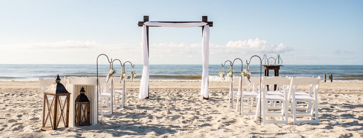 A wedding alter set up on a beach in North Myrtle beach with wedding chairs and wedding awning