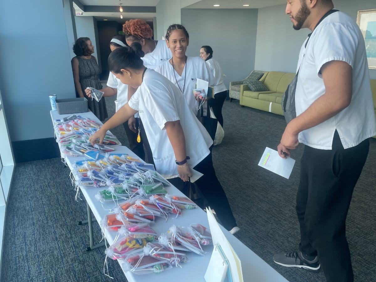 Staff selecting colorful goody bags from a table at an appreciation event at Avista Resort.