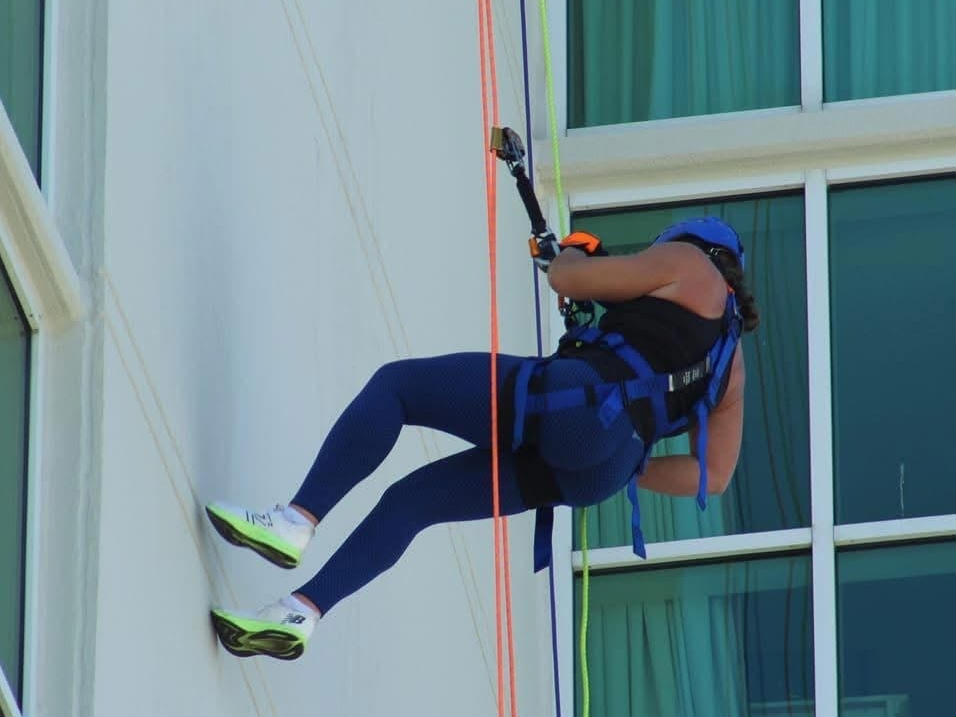 Group of smiling people wearing hawaiian leis at an outdoor table