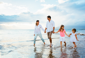 A family walking together on a beach in Myrtle Beach.