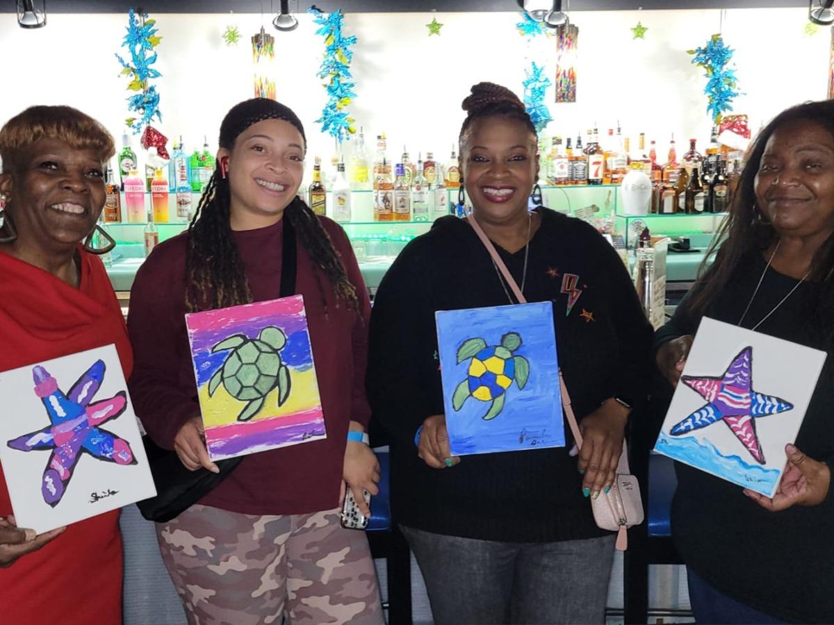 A group of ladies holding handmade painting in North Myrtle Beac