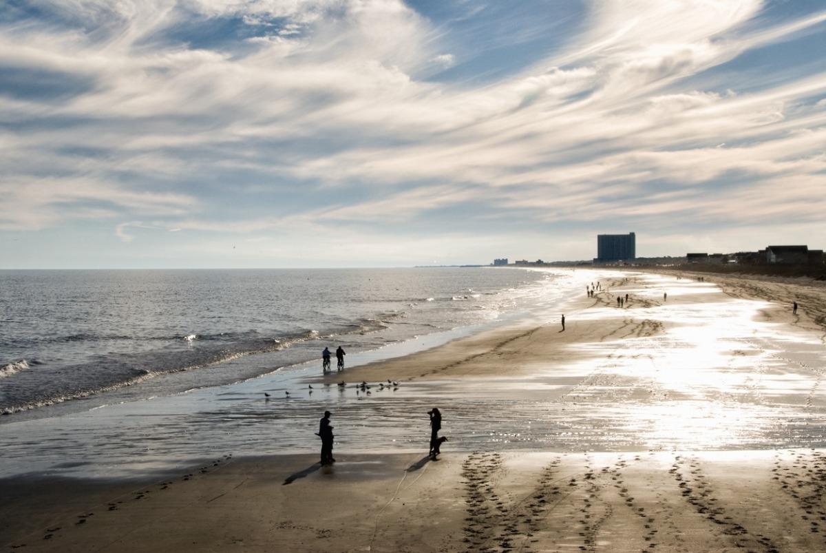 less crowds on the beach where people are walking along the seashore